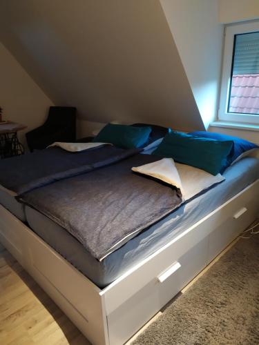 LübberstedtGästehaus Hölting的一张带蓝色和白色枕头的床