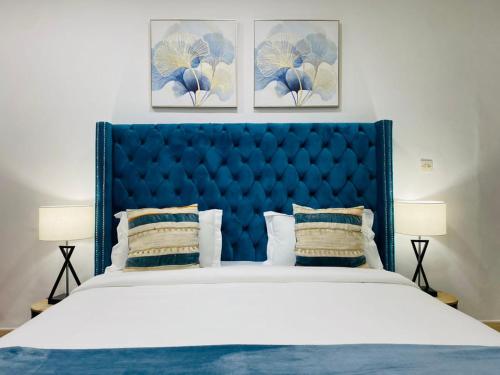 达喀尔ILLIYIN Boutique Hotel的卧室内的一张带蓝色床头板的大床