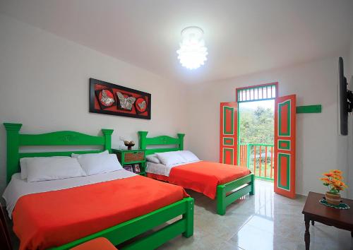 萨兰托Hotel Casa Quinta Salento的绿色和红色客房的两张床