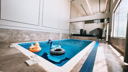 阿可贺巴شاليه رويال الخبر - Royal Resort AL Khobar的一座位于大楼中央的游泳池,里面有两个鸭子