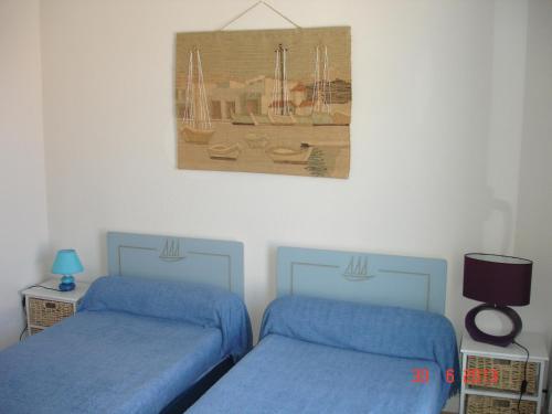 沙特拉永普拉日L' Ecume de Mer的卧室配有两张床,墙上挂着一幅画