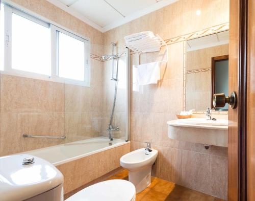 桑亨霍特龙科索酒店的浴室配有卫生间、盥洗盆和浴缸。