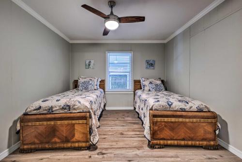 格尔夫波特Charming Gulfport Home about 2 Mi to Marina的一间卧室配有两张床和吊扇