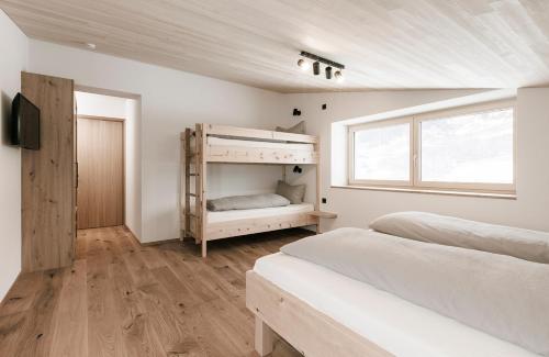 梅劳Ferienhaus Schihütte Mellau的一间卧室设有两张双层床和一扇窗户。