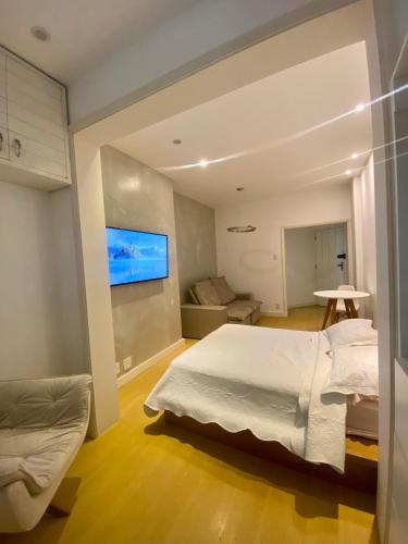 里约热内卢Apartamento Encantador Leme - Prédio na Orla的卧室配有一张床,墙上配有电视。