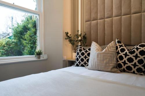 格拉斯哥The Wilton Suite - Your Private 5* Escape!的卧室配有带枕头的床铺和窗户。