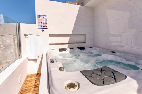 明德卢Penthouse with jacuzzi and sea view, Morabeza Deluxe的浴室配有蓝色海水浴缸
