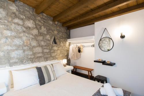 米克诺斯城Mykonos Amazing Apartments 2的一间卧室设有一张床和石墙
