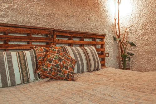 达纳Hobbit village的一间卧室配有带枕头的床