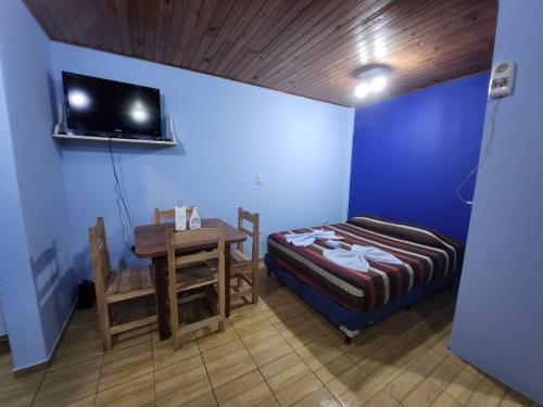 伊瓜苏港Rinconcito Iguazú的客房设有1张床、1张桌子和1台电视。