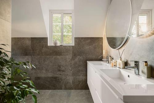 卑尔根Villa Bergen. Historic luxury near the city centre的浴室设有白色水槽和镜子
