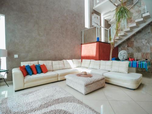 坎昆Spacious Luxury Home的客厅配有白色沙发和凳子