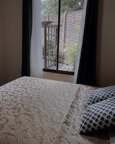 福尔图纳Honey House 2018的一间卧室设有一张床,享有窗户的景色