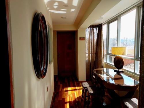 库斯科Zans Apartments Cusco的一间设有玻璃桌和窗户的房间