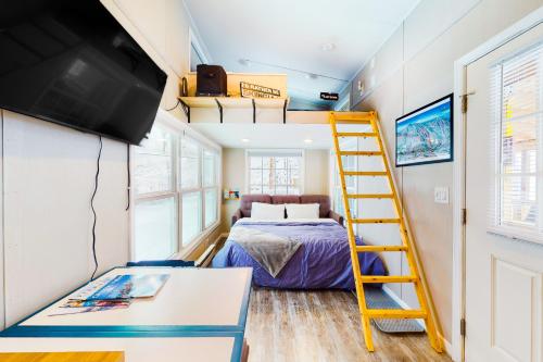 拉德洛Tiny Homes on Pleasant的一间小卧室,配有双层床和黄色梯子