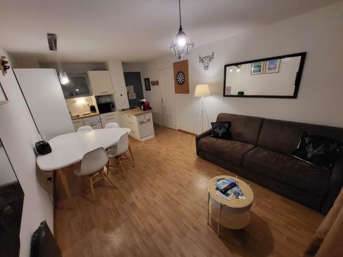 贝斯和圣阿纳斯泰斯Appartement 2 pièces, les Chalets de Super-Besse的客厅配有沙发和桌子