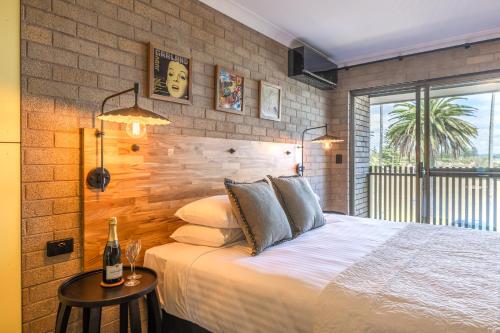 伯马吉Bermagui Beach Hotel的一间卧室设有一张床和砖墙