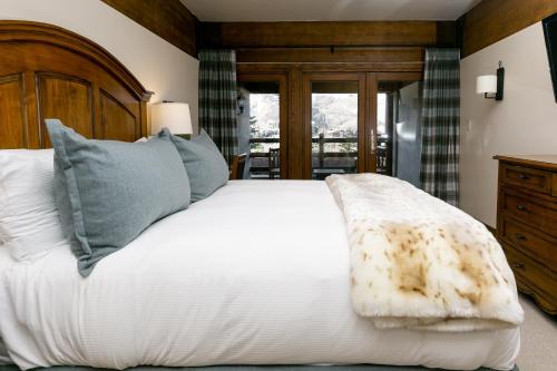 帕克城Deluxe King Room with Deck Hotel Room的卧室配有白色的床和木制床头板