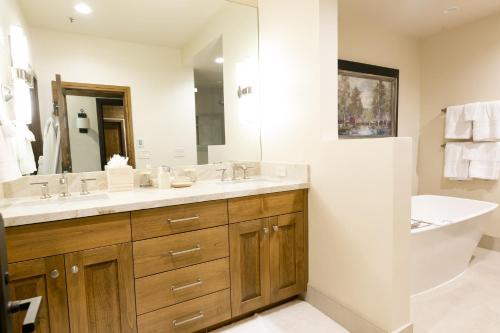 帕克城Deluxe King Room with Deck Hotel Room的浴室配有盥洗盆、镜子和浴缸