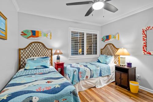 大西洋滩Dunescape Villas 211的一间卧室配有两张床和吊扇