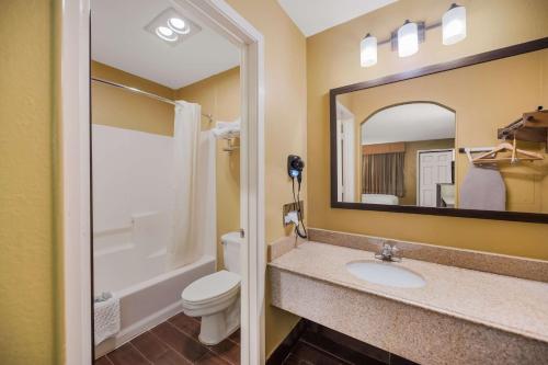 Mount PleasantSureStay Hotel by Best Western Mt Pleasant的一间带水槽、卫生间和镜子的浴室