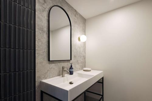 卧龙岗Hotel TOTTO Wollongong的一间带水槽和镜子的浴室