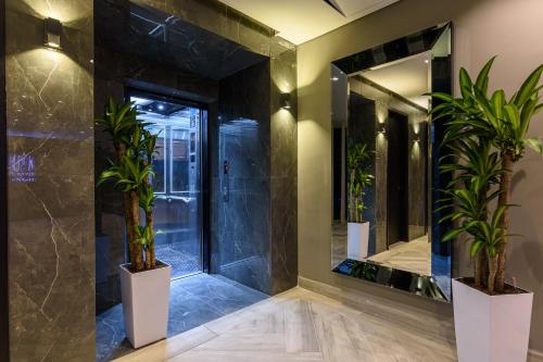 麦德林4 Sur Hotel的浴室设有大镜子和盆栽植物