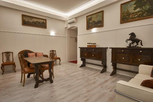 博洛尼亚Cuore di Bologna Suites的客厅配有桌椅和橱柜。