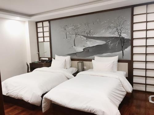 河内布兰迪富士酒店的墙上画画的房间里设有两张床