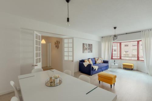 里斯本Elegant 3 bedroom apt - City centre - garage - metro的客厅配有蓝色的沙发和桌子
