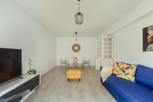 里斯本Elegant 3 bedroom apt - City centre - garage - metro的客厅配有蓝色的沙发和黄色的凳子
