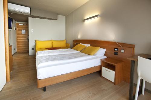 马尔切西内Ambienthotel Spiaggia的一间卧室配有一张带黄色枕头的大床
