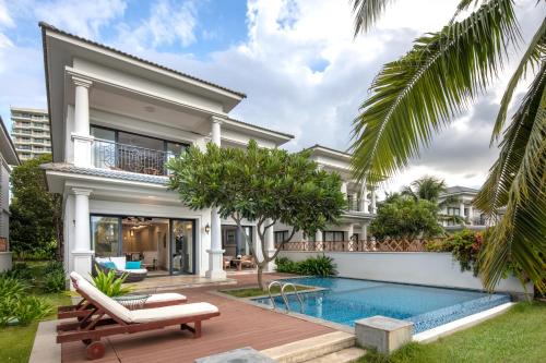 金兰Meliá Vinpearl Cam Ranh Beach Resort的一座带游泳池和房子的别墅