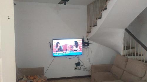 瓜拉图巴Sobrado Guaratuba Central的客厅设有挂在墙上的电视