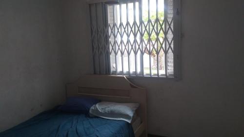瓜拉图巴Sobrado Guaratuba Central的小房间设有床和窗户