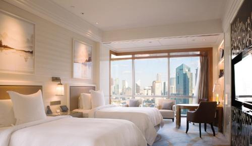 天津天津四季酒店的酒店客房设有两张床和大窗户。