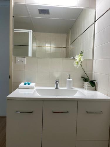 黄金海岸Oceania on Burleigh Beach的浴室设有白色水槽和镜子