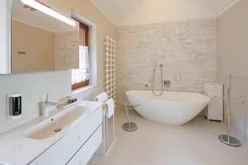 卡罗维发利Hotel Château Cihelny的浴室配有大型白色浴缸和水槽