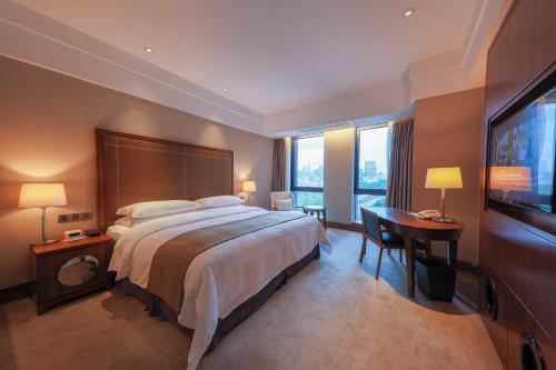 深圳兰赫美特酒店的酒店客房设有一张大床和一张书桌。