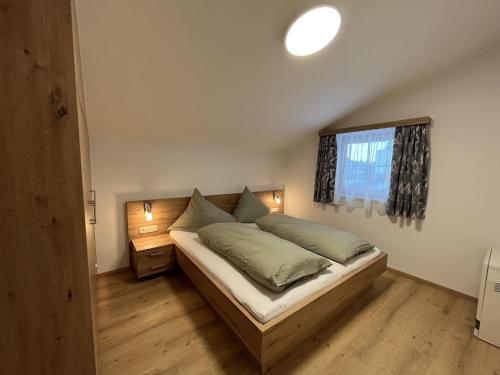 平茨高谷地瓦尔德Cozy apartment in Wald im Pinzgau with balcony and barbecue area的一间卧室设有一张床和一个窗口