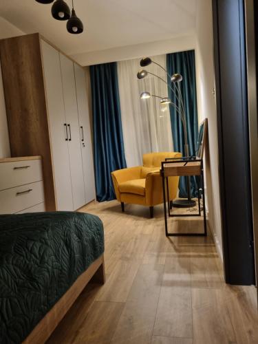 凯尔采Apartament Loft KB-Ściegiennego (garaż, centrum)的一间卧室配有一张床和一张黄色椅子