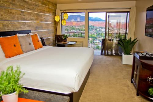 圣乔治悬崖之上酒店的一间带大床的卧室和一个阳台