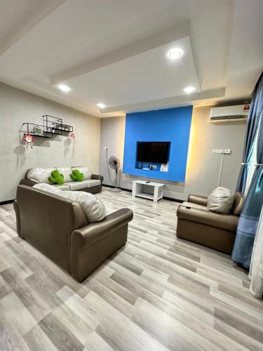 仙本那ANG LEE HOLIDAY HOME 1的客厅配有2张沙发和1台平面电视