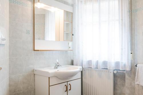 塞纳莱斯Residence Am Wegkreuz的白色的浴室设有水槽和镜子
