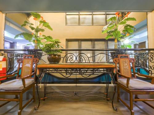 马尼拉Super OYO Capital O 907 Ceo Flats的阳台上配有桌椅和植物
