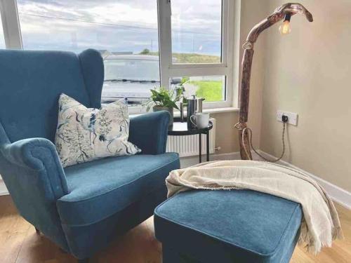 LettermacawardDonegal Beach Cottage with Sea Views, sleeps six的窗户房间里摆放着蓝色椅子和凳子