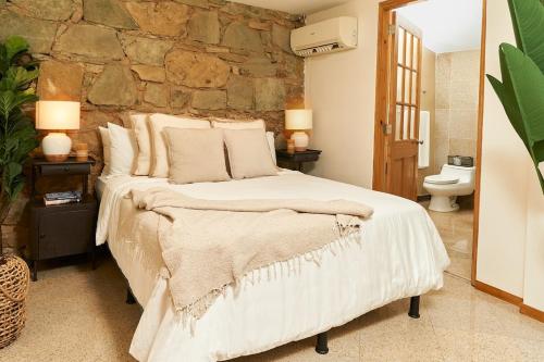 巴拿马城AmazINN Places private Splash Pool and relaxing Sound of Sea的一间卧室设有一张大床和石墙