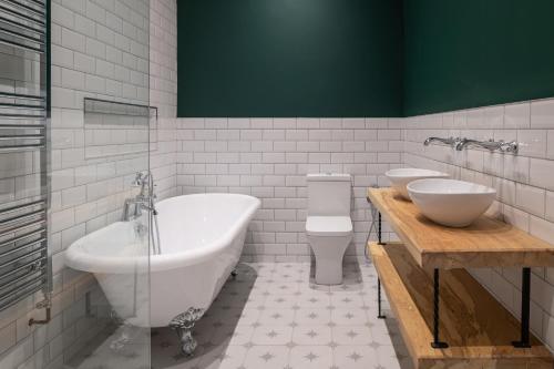 布莱奈费斯蒂尼奥格Finest Retreats - Capel Salem的一间带两个盥洗盆、浴缸和卫生间的浴室