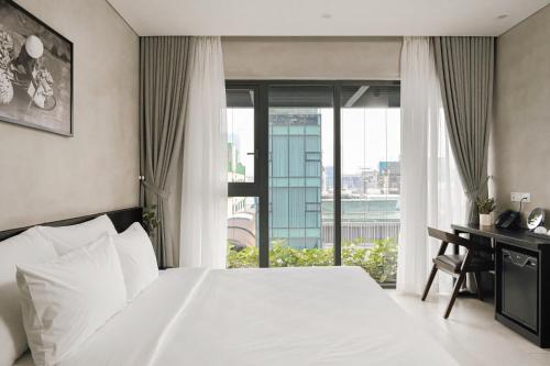 胡志明市Triple E Hotel Metro Ben Thanh的一间卧室配有一张床和一张带窗户的书桌