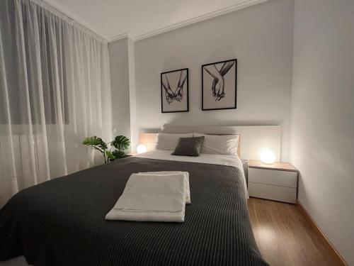 圣比森特德拉松谢拉Apartamento San Vicente de la Sonsierra Confort的卧室配有一张大床,墙上挂有两张照片
